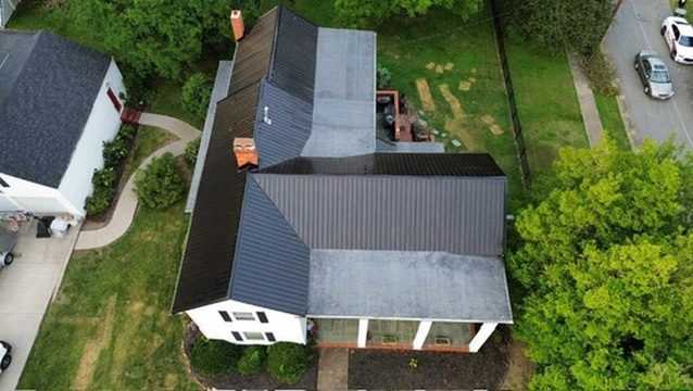 A house with a black metal roof and black gutters.
