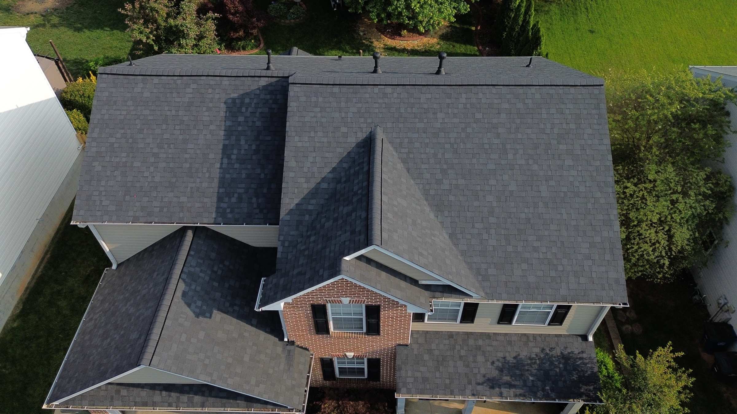 The same house from above with a new dark gray shingle roof.